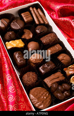 Scatola di cioccolatini su seta rossa Foto Stock