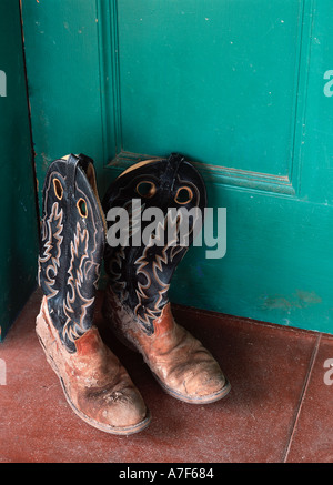 Stivali da cowboy di sinistra al di fuori di un ranch casa porta Foto Stock