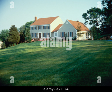 Casa del telaio con disegni breezeway al garage vagliati in veranda sul retro sulla cima di una collina impostazione di lusso con campi e prati Foto Stock