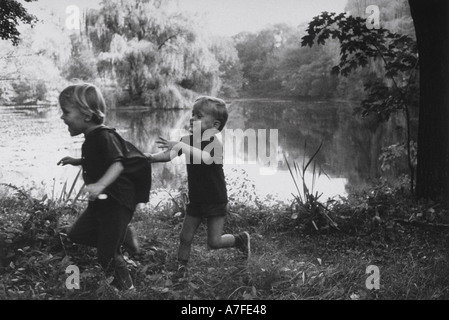 Frolic di tag rivela le emozioni del piccolo fratello cattura fino a Big Sister al lago idilliaco impostazione Foto Stock