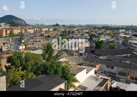 Un ampio angolo di veduta aerea della città di Dio (Cidade de Deus) Favela che mostra i nuovi edifici del Rio più ricchi all'orizzonte. Foto Stock