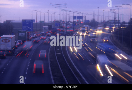 Faro anteriore di percorsi di traffico che viaggia sull'autostrada M62 al crepuscolo Leeds REGNO UNITO Foto Stock