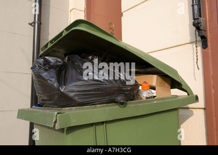Green wheely bin pieno di spazzatura CHELTENHAM REGNO UNITO Foto Stock
