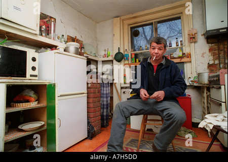 Seduta residente nella cucina di una Londra Sud squat. Foto Stock
