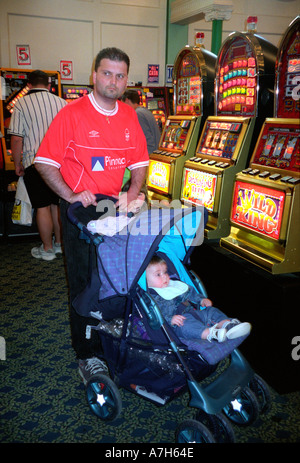 Uomo e bambino in giochi arcade giocando su macchine di frutta. Foto Stock