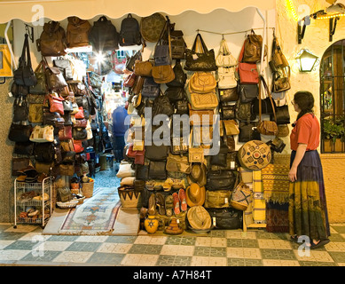 Turista guardando le borsette in cuoio e la merce in vendita al di fuori del negozio nella sera Nerja spagna Foto Stock