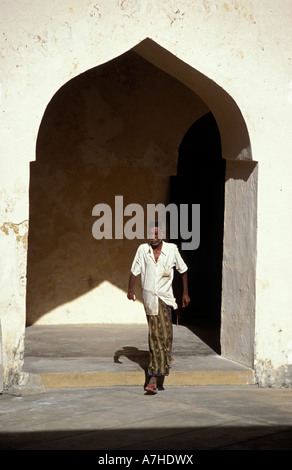 Il swahili uomo a camminare attraverso la fortezza araba, Lamu, Kenya Foto Stock