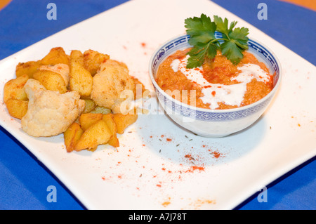 Yellow dal in una ciotola e Aloo Gobi su un piatto bianco, piatti tradizionali indiani serviti con spezie e decorazioni. Foto Stock