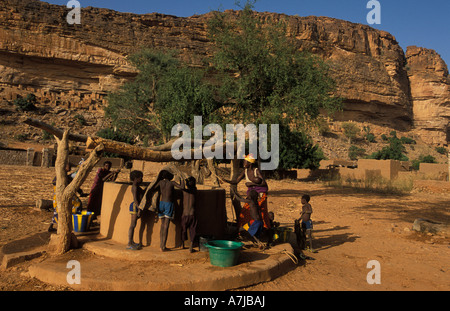 Le donne a raccogliere acqua dal pozzo del villaggio, Telí village, Paese Dogon del Mali Foto Stock