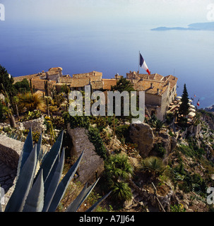 Guardando verso il basso in corrispondenza di tri-colore battenti bandiera su antico borgo medioevale in cima alla scogliera villaggio costiero di Eze Sur Mer nel sud della Francia Foto Stock