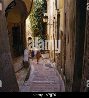 Coppia giovane a piedi fino tipico old street in classico pittoresca scogliera villaggio costiero di Roquebrune a sud della Francia Foto Stock