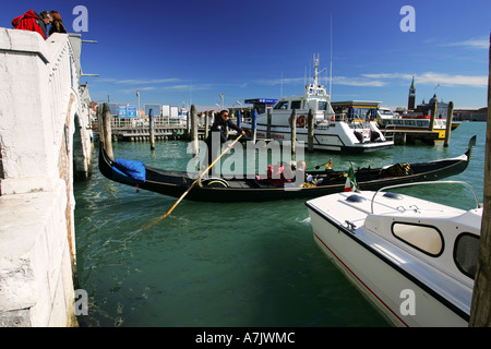 Una tipica gondola veneziana barca emerge da sotto un ponte nel Canal Grande nella laguna di Venezia Italia Europa UE Foto Stock