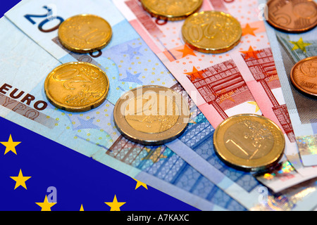 Denaro Euro contro un Euro bandiera dello sfondo. Foto Stock