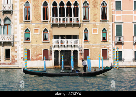 Tipica scena veneziana di una gondola nave passeggeri il trasporto di turisti verso il basso il Canal Grande nel centro di Venezia Italia Europa Foto Stock