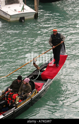 Coppia giovane per fare una romantica gita in barca nel tipico gondolar veneziano sul Canal Grande vicino al Ponte di Rialto Venezia Italia UE Foto Stock