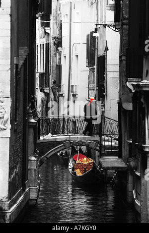 Gondolar veneziano uomo attende su iconica backstreet tipico ponte per il passaggio di passeggeri per turismo, Venezia Italia Europa UE Foto Stock