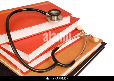 Uno stetoscopio su una pila di libri di riferimento isolato su bianco Foto Stock