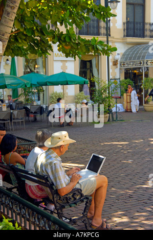 Un turista usando un computer portatile in Hidalgo park, Merida Foto Stock