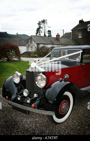 Rosso e nero vintage Rolls Royce auto nozze con il tipico nastro bianco decorazioni attende per gli sposi novelli sposi Foto Stock