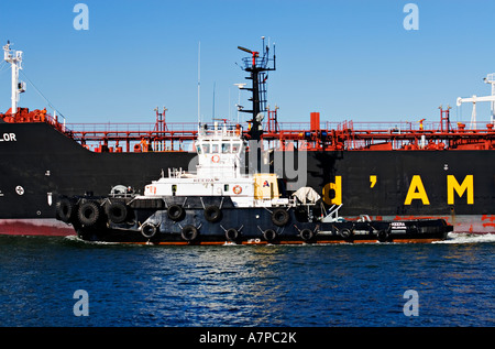 Industria di spedizione / petroliera di petrolio e un rimorchiatore a traino in assist.Porto di Melbourne in Australia. Foto Stock