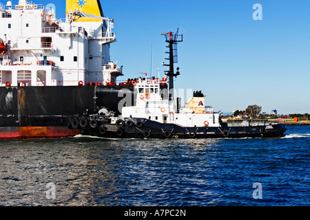 Industria di spedizione / petroliera di petrolio e un rimorchiatore a traino in assist.Porto di Melbourne in Australia. Foto Stock