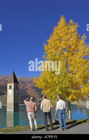 I turisti vista sul Passo Resia lago sunken chiesa torre del vecchio graun alto adige italia Foto Stock