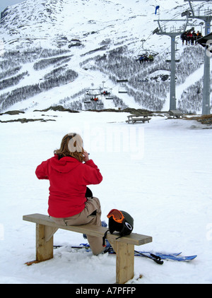 Giovane donna parlando sul suo telefono cellulare in Norweigan sci e snowboard resort di Hemsedal Foto Stock