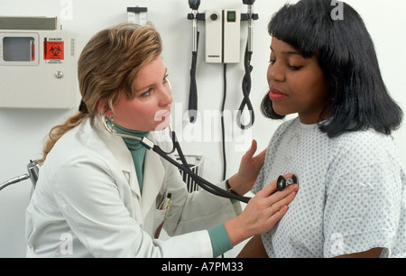 Medico ascolta paziente s petto durante la visita di office Foto Stock