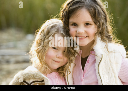 Ritratto di due ragazze sorridenti e abbracciando all'aperto Foto Stock