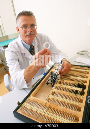 In interni armadio ambulatoriale uomo maturo 45 50 dai capelli grigi baffi sorriso sorridente bicchieri medico oculista optomerist sit Foto Stock