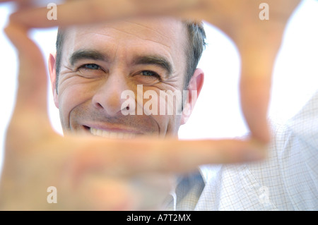 Ritratto di uomo maturo rendendo il telaio con le dita Foto Stock