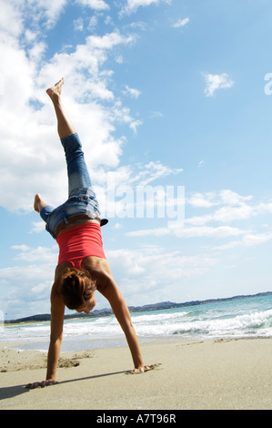 Vista posteriore della donna facendo appoggiate sulla spiaggia Foto Stock