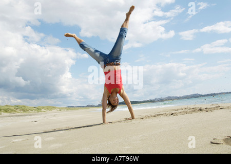 Donna facendo appoggiate sulla spiaggia Foto Stock