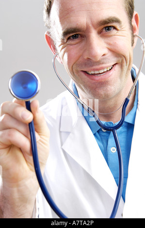 Close-up di maschio medico tenendo lo stetoscopio e sorridente Foto Stock