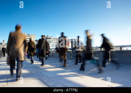 Il trudge al lavoro pendolari attraversando il Ponte di Londra sul modo di lavorare Londra Inghilterra NR Foto Stock