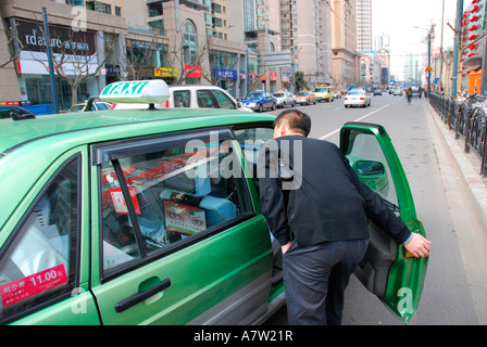 Imprenditore salutando una cabina o un taxi a Shanghai in Cina Foto Stock