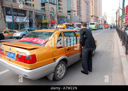 Imprenditore salutando una cabina o un taxi a Shanghai in Cina Foto Stock