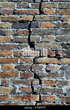 Un vecchio muro di mattoni con una grande spaccatura in esso Foto Stock