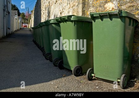 Una fila di verde scomparti wheelie pronto per la raccolta dei rifiuti in Cornovaglia,Inghilterra Foto Stock