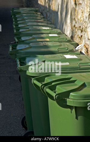 Una fila di verde scomparti wheelie pronto per la raccolta dei rifiuti in Cornovaglia,Inghilterra Foto Stock