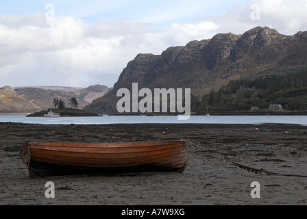 Una barca a remi a bassa marea sulle rive di Loch Carron dal villaggio di Plockton in Wester Ross,Scozia,Gran Bretagna Foto Stock