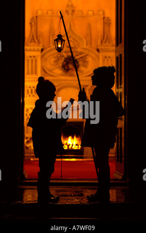 Bambini CANTI DI NATALE IN UNA CASA DI CAMPAGNA Foto Stock