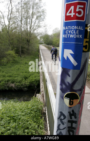 Ciclista su strada ciclabile oltre il ponte con la nazionale rete ciclabile segno sulla lampada post Foto Stock