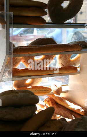 Varietà di pane visualizzati nella finestra al panificio della sezione di Belmont del Bronx, NY, STATI UNITI D'AMERICA Foto Stock