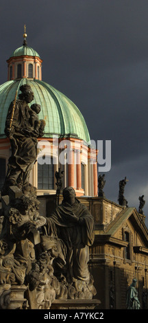 La statua della Madonna e di San Bernardo sul Ponte Carlo a Praga con la cupola della chiesa di San Francesco dietro Foto Stock