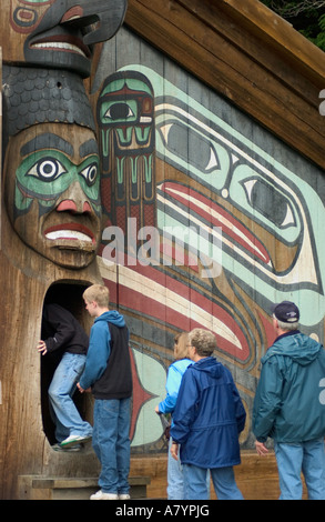 Stati Uniti d'America, Alaska Ketchikan, Totem ansa del parco statale, Totem Clan house con tourist entrando. Foto Stock