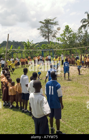 Gli studenti adolescenti giocano in una partita di pallavolo scolastica su un terreno sportivo con tifosi che guardano da linee laterali, regione occidentale, Ghana Africa occidentale Foto Stock