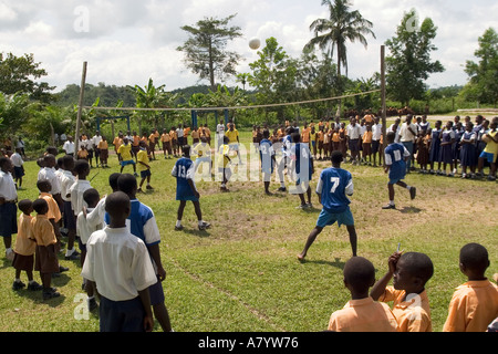 Gli studenti adolescenti giocano in una partita di pallavolo scolastica su un terreno sportivo con tifosi che guardano da linee laterali, regione occidentale, Ghana Africa occidentale Foto Stock