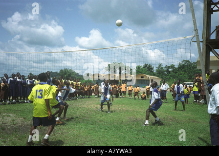 Gli studenti adolescenti giocano in una partita di pallavolo scolastica su un terreno sportivo con tifosi che guardano da linee laterali, regione occidentale, Ghana Africa occidentale Foto Stock