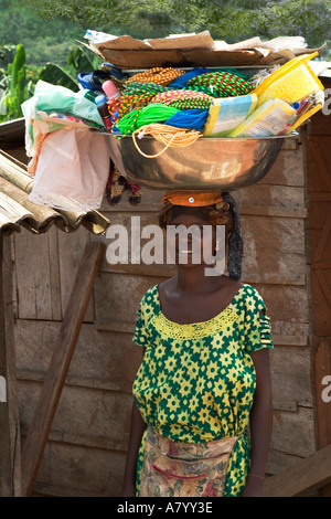 Piuttosto West African street hawker vendita di merci dalla coppa portati sulla sua testa, Ghana Africa occidentale Foto Stock